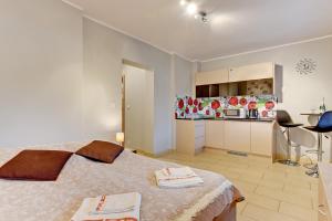 a bedroom with a large bed and a kitchen at Villa Arkodes in Gdańsk