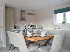 a kitchen with a wooden table and chairs at Lily Lodge - Uk31958 in Dibaig