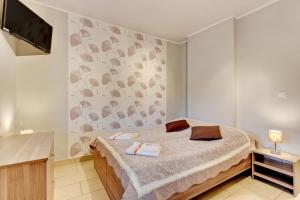 a bedroom with a bed and a tv on a wall at Villa Arkodes in Gdańsk