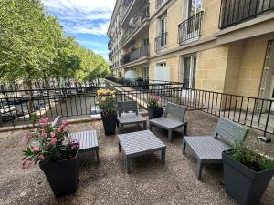 a group of benches and potted plants on a balcony at Studio - Saint-Michel in Le Havre