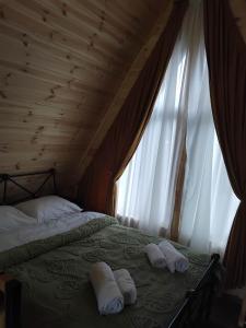 a bed with two towels on it with a window at Cottage MTIS DZIRSHI in Ach'khoti