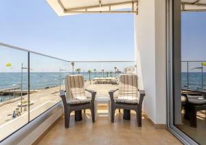 a balcony with a table and chairs and a view of the ocean at Lighthouse Seafront Panorama - Kato Paphos Central in Paphos