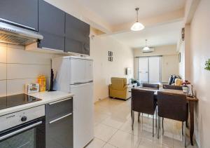 a kitchen with a refrigerator and a table with chairs at Lighthouse Seafront Panorama - Kato Paphos Central in Paphos