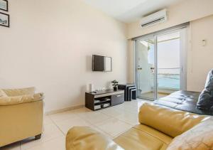 a living room with a couch and a tv at Lighthouse Seafront Panorama - Kato Paphos Central in Paphos