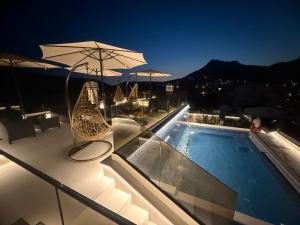a swimming pool with chairs and an umbrella on a building at Apartments Pericic LUX in Sutomore +117 photos