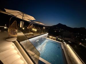 a swimming pool on top of a building with an umbrella at Apartments Pericic LUX in Sutomore