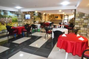 a restaurant with red and white tables and chairs at ALVI SEVEN Hotel in Douala