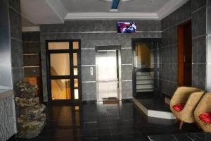 a living room with a tv on a wall at ALVI SEVEN Hotel in Douala