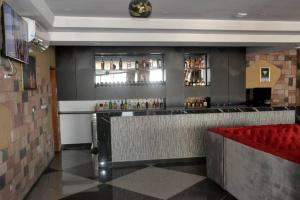 a bar in a restaurant with a red bench at ALVI SEVEN Hotel in Douala +5 photos