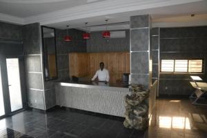 a man standing at a counter in a kitchen at ALVI SEVEN Hotel in Douala