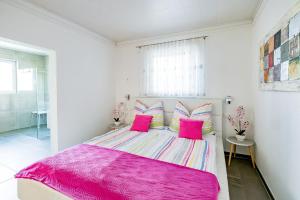 a bedroom with a pink bed with pink pillows at Freiraum Urlaubsapartment in Villach