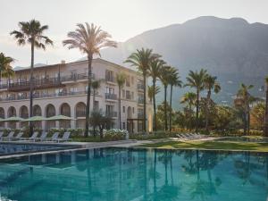a hotel with palm trees and a swimming pool at Grecotel Filoxenia Kalamata in Kalamata