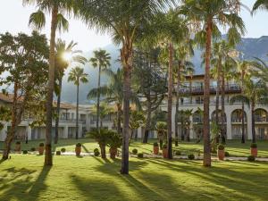 a resort with palm trees in front of a building at Grecotel Filoxenia Kalamata in Kalamata