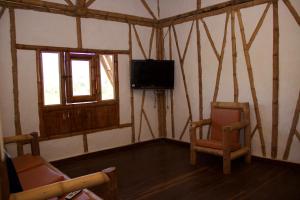 a living room with two chairs and a television at Hotel La Montoya in Curití