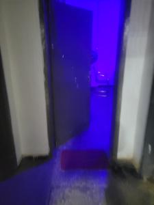 a dark room with a blue and purple door at Mohe's place in Ilorin