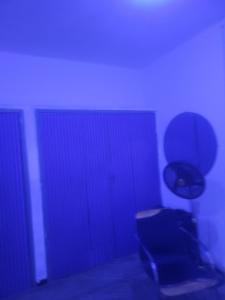 a blue room with a chair and a door at Mohe's place in Ilorin