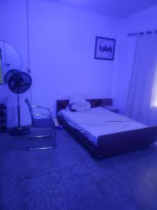 a bedroom with a bed and a chair in a room at Mohe's place in Ilorin