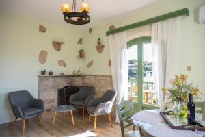 a living room with a fireplace and a table and chairs at Bellevue Apartments in Sitia