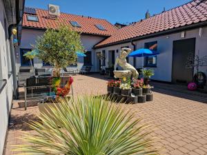 a courtyard with a statue of a dog and flowers at Apartamenty MARINA Puck in Puck
