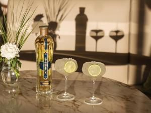 a bottle of wine and two glasses with lemon slices at Grecotel Filoxenia Kalamata in Kalamata