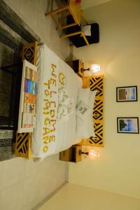 a sign on a wall in a bathroom with some lights at Migano Hotel in Ruhengeri