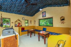 a room with two tables and a tv in it at Sariska Forest Trail in Rāmsinghpura