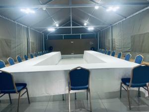 a conference room with a large white table and chairs at Sky Apartments in Harare
