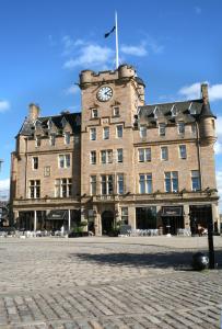 ein großes Backsteingebäude mit einer Uhr drauf in der Unterkunft Malmaison Edinburgh in Edinburgh