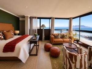 a bedroom with a large bed and a living room at Belle Maroc Boutique Hotel in Bloubergstrand