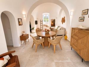 a living room with a table and chairs at I Trulli di Federico in Selva di Fasano