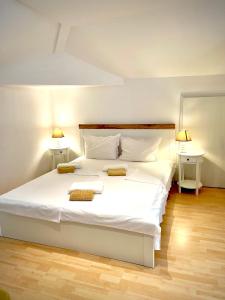 a bedroom with a white bed with two pillows on it at Dimitrovi Guesthouse - Peaceful Stay near Beach with Garden, Sarafovo in Burgas
