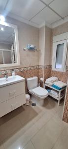 a bathroom with a toilet and a sink and a mirror at Egabro Apartamento in Cabra