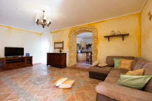 a living room with a couch and a tv at Sa Branda Costa Country Alghero in Santa Maria la Palma