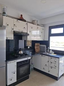 a kitchen with white cabinets and a stove at Modern Apartment with Pool & Sea View in Casablanca