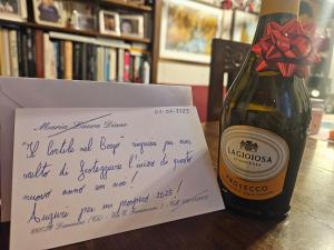 a handwritten letter next to a bottle of wine at Il Cortile nel Borgo in Lanciano
