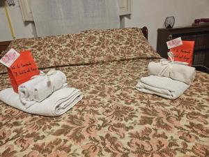 a bed with towels on it with signs on it at Il Cortile nel Borgo in Lanciano