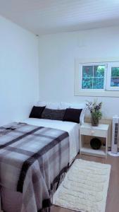 a white bedroom with a bed and a window at BAPA STAYs in Kristianstad
