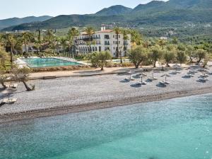 an aerial view of a beach with chairs and water at Grecotel Filoxenia Kalamata in Kalamata +29 photos