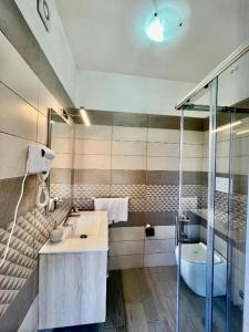 a bathroom with a sink and a toilet and a shower at LaDependance Hotel Scilla in Scilla +16 photos