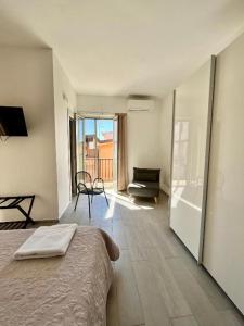 a bedroom with a bed and a view of a balcony at LaDependance Hotel Scilla in Scilla