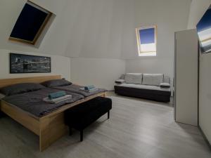 a bedroom with a large bed and a couch at Crystalapartmanhaz in Gyula