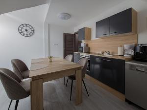 a kitchen with a wooden table and chairs in a room at Crystalapartmanhaz in Gyula