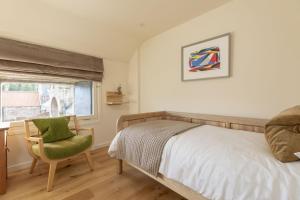 a bedroom with a bed and a chair and a window at Papple Steading in East Linton