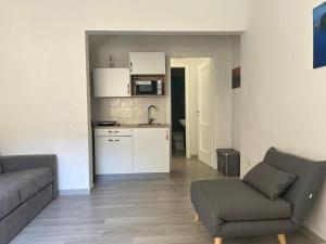 a living room with a couch and a kitchen at LaDependance Hotel Scilla in Scilla