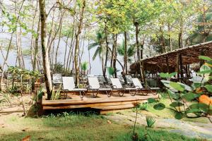 a group of chairs sitting on a wooden deck at Natura Cabana Boutique Hotel & SPA in Cabarete