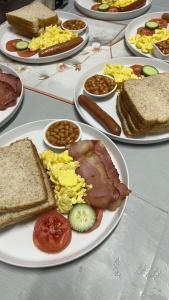 a table with plates of breakfast food on it at Solomon Guest House in Maseru