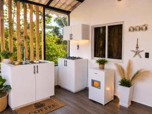 a kitchen with white cabinets and a sink at Xamanai Playa Rincón III in Las Galeras +25 photos