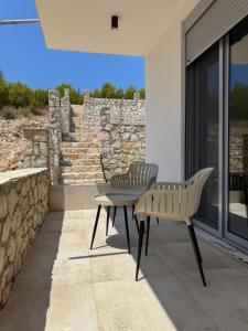a patio with a table and chairs and a stone wall at Paradise Luxury in Ulcinj