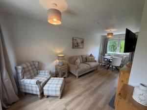 a living room with a couch and chairs and a table at The Narrows - Macaulay Letting in Rhu