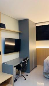 a room with a desk with a chair and a bed at Studio Chico 02 in Espirito Santo Do Pinhal